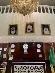a room with clocks on the wall and a chandelier at فندق الروضة قريب من حفلات توصيل للحرم مجاناً in Al Khansāk
