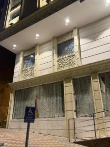 a building with windows and a sign in front of it at فندق الروضة قريب من حفلات توصيل للحرم مجاناً in Al Khansāk