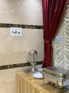 a table with a machine on it next to a curtain at فندق الروضة قريب من حفلات توصيل للحرم مجاناً in Al Khansāk
