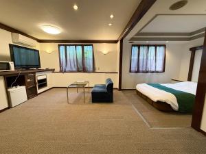 a hotel room with a bed and a tv at ジーアール柳井 in Yanai