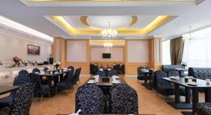 un restaurant avec des tables et des chaises dans une salle dans l'établissement Vienna Hotel Jiangxi Jiujiang Gongqingcheng High-Speed Railway Station, à Gongqingcheng