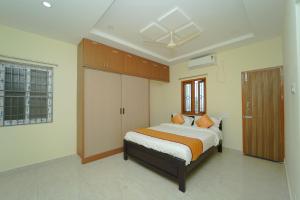 a bedroom with a large bed in a room at Hotel O Pinaka Grand A Luxurious Homestay in Narasingāpuram