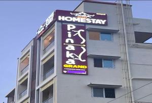 a sign on the side of a building at Hotel O Pinaka Grand A Luxurious Homestay in Narasingāpuram
