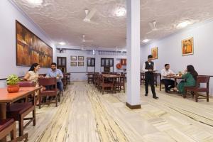 a group of people sitting at tables in a restaurant at FabHotel Jai Mangal Palace - Sindhi camp bus stand, Jaipur railway station,Sindhicamp metro station in Jaipur
