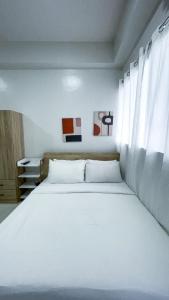 a bedroom with a white bed and a window at WV 32 Urban Scenic Studio in Sampong