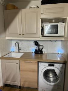 een keuken met een wasmachine en een magnetron bij 5 personnes, 2Pieces exceptionnel havre de détente et de confort, immense terrasse, vue incroyable, Tout pédestre, à 10m du funiculaire, parking in Isola 2000