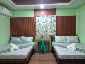 a bedroom with two beds and a blue chair at JANHOUR PLACE in San Vicente