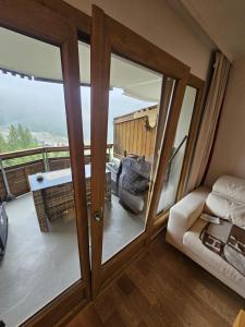 een kamer met een glazen schuifdeur en een balkon bij 5 personnes, 2Pieces exceptionnel havre de détente et de confort, immense terrasse, vue incroyable, Tout pédestre, à 10m du funiculaire, parking in Isola 2000