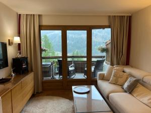 een woonkamer met een bank en een groot raam bij 5 personnes, 2Pieces exceptionnel havre de détente et de confort, immense terrasse, vue incroyable, Tout pédestre, à 10m du funiculaire, parking in Isola 2000