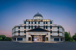 a large building with a sign on top of it at Shanghai Jiading Pingcheng Road Atour Light Hotel in Shanghai
