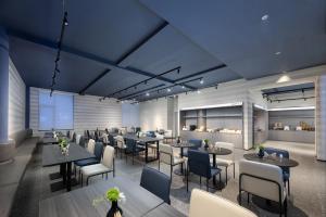 a restaurant with tables and chairs in a room at Shanghai Jiading Pingcheng Road Atour Light Hotel in Shanghai