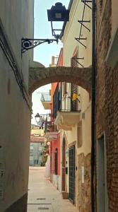 an alley with an archway between two buildings at La Dimora di Tommaso Apartment - Dimora storica Bike Friendly in Ortona