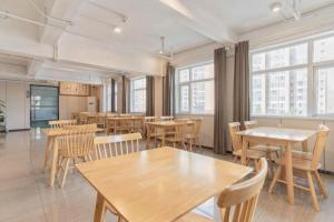 a dining room with tables and chairs and windows at Borrman Hotel Dongguan Houjie Wanda Plaza Liaoxia Metro Station in Dongguan