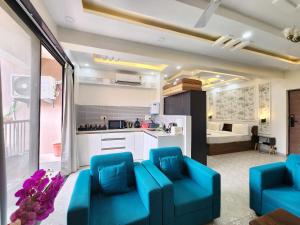 a living room with blue chairs and a kitchen at Romantic Goa Studio with Mangrove view - Walk to Candolim Beach, Ideal for Couples in Candolim