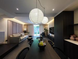 a living room with a dining table and a couch at Huguang Hidden Villa Hotel in Chongqing