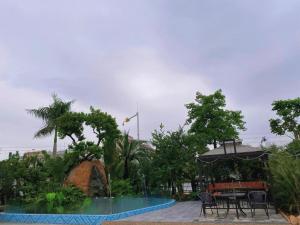 a pool with a table and chairs and an umbrella at Vienna Hotel Guangzhou Baiyun Airport Huadu Avenue in Huadu