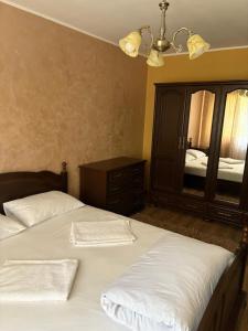 a bedroom with two beds and a large mirror at Apartament Leonardo in Roman