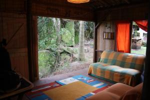 ein Wohnzimmer mit einer Couch und einem Fenster in der Unterkunft Pedra Escondida in Imbituba