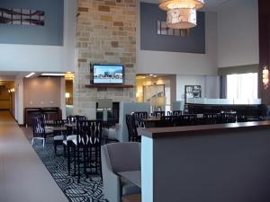 a restaurant with tables and chairs and a bar at Holiday Inn Express & Suites Fredericksburg By IHG in Fredericksburg