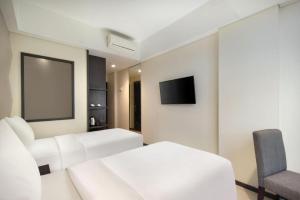 a hotel room with two beds and a tv at Fashion Hotel Legian in Legian +86 photos