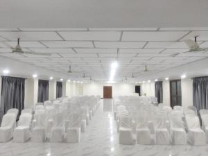 a room filled with white chairs in a room at The Whistling Pine Woods in Varagampadi