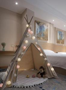 a bed with a teddy bear in a bedroom at T Social Hotel Guangzhou Railway Station Branch in Guangzhou