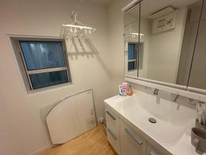 a bathroom with a sink and a mirror and a window at さくら旅館阿佐谷北千利休 in Tokyo +9 photos