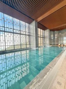 a large swimming pool in a building with windows at Antara Genting Premium KL View 2BR Karaoke K2 in Genting Highlands