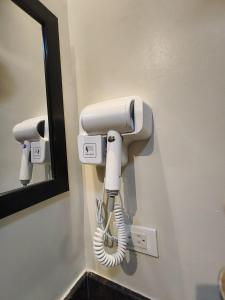 a white phone on a wall next to a mirror at 2-BR Condo near Major Tourist Spots in Baguio in Sampong