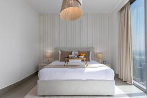 a bedroom with a bed with a table on it at Maison Privee - City Heights Retreat with Panoramic Skyline Views in Dubai +10 photos