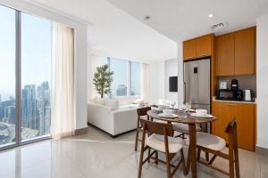 a kitchen and living room with a table and chairs at Maison Privee - City Heights Retreat with Panoramic Skyline Views in Dubai