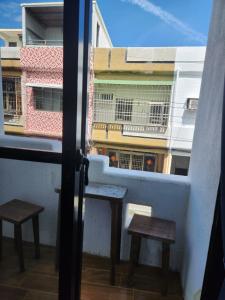 Una vista de un balcón con dos bancos y un edificio. en And宅, en Hengchun