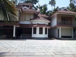 a large house with a driveway in front of it at Athithi Inn Homestay in Vaduvanchal