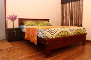 a bedroom with a bed with a colorful comforter at Athithi Inn Homestay in Vaduvanchal