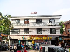 a building on a street with cars parked in front of it at Harmony Residence in Trivandrum