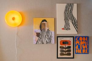 a wall with paintings and a yellow balloon and pictures at Otter Stay Lite - Shinsakae in Nagoya