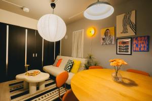 a living room with a table and a couch at Otter Stay Lite - Shinsakae in Nagoya