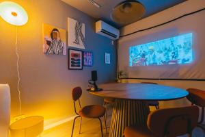 a room with a table and a tv on a wall at Otter Stay Lite - Shinsakae in Nagoya