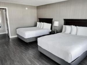 Dos camas en una habitación de hotel con dos faldones. en The Georgian Resort, en Lake George
