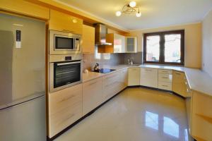 a large kitchen with white cabinets and a window at Holiday home 200 qm, Kolobrzeg in Kołobrzeg