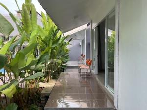 Un patio interior con plantas y una silla en una casa. en Trisula Room, Pool and Warung, en Badung