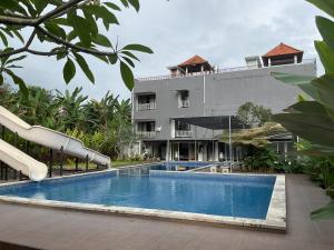 Un complejo con piscina y un edificio. en Trisula Room, Pool and Warung, en Badung