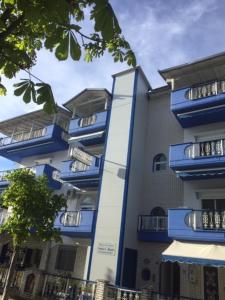 a building with blue balconies on the side of it at Fotini's Beach in Olympiaki Akti