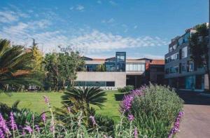 a building with a yard with flowers in front of it at Xana Hotelle Chengdu East Railway Station Kaide Plaza in Chengdu