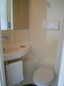 une salle de bain blanche avec un lavabo et des toilettes dans l'établissement Good Night Hotel, à Arques