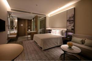 a hotel room with a bed and a couch at Wanda JIN Baise in Qitang +195 photos