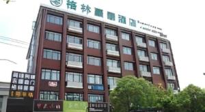 XiduにあるGreenTree Inn Shanghai Fengxian District Xiaotang Metro Stationの上に時計がある高い建物