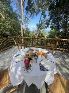a table with plates of food on a deck at Kimulimuli Green Heaven in Kilindoni