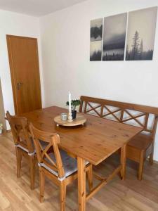 una mesa de madera con 2 sillas y una vela. en Falkenstein Loft 55, en Zwiesel