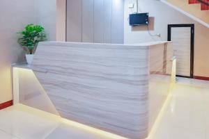 a white counter in a room with a tv at Urbanview SANT Hotel Syariah near Stasiun Tegal in Tegal +16 photos